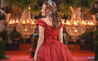 Vestido de gala rojo en salón con candelabros